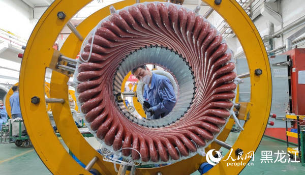 哈電集團(tuán)佳電股份電工車間職工正在將定子槽楔嵌入鐵心內(nèi)。????人民網(wǎng) 尚城攝