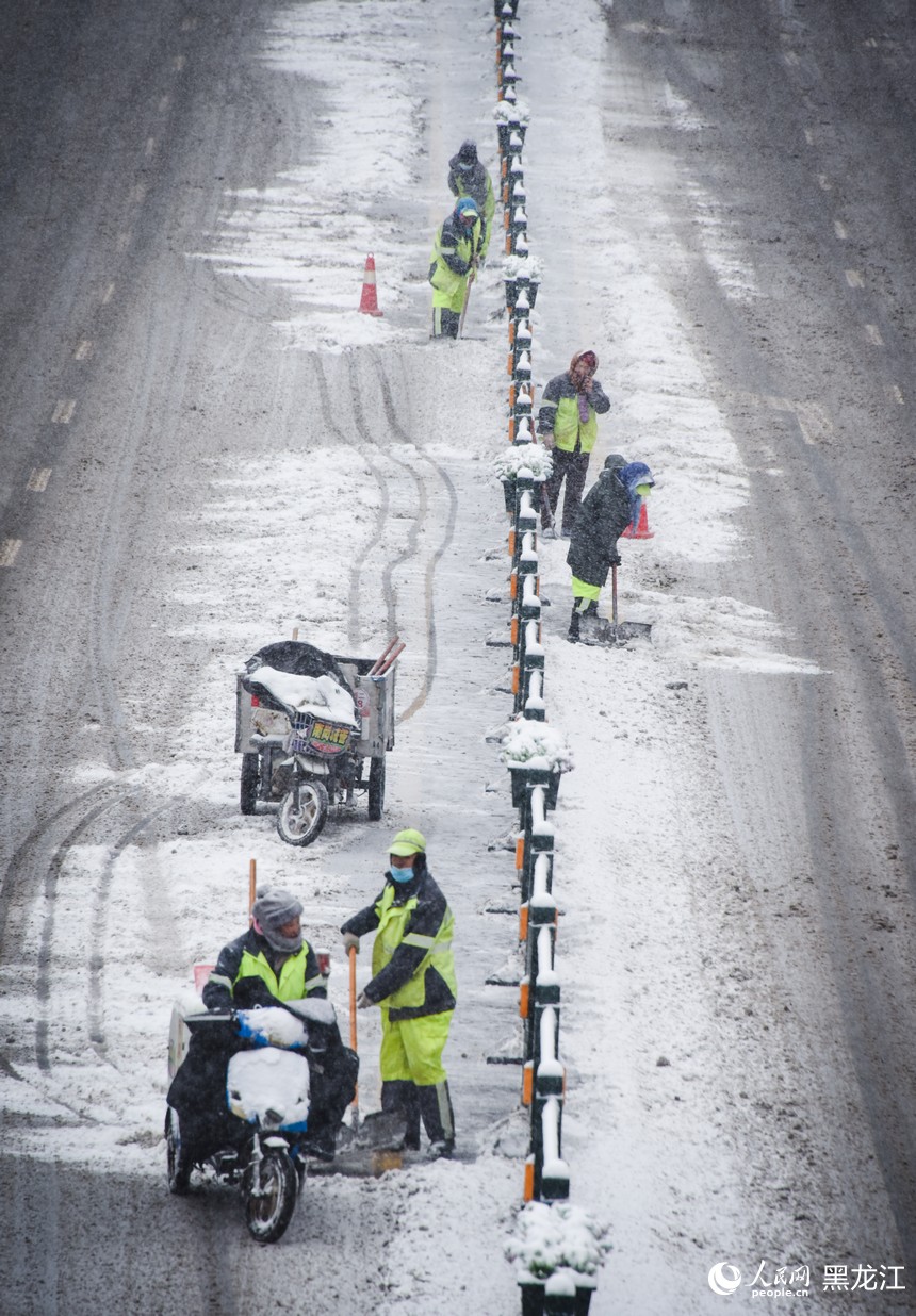 環(huán)衛(wèi)工人正在清理道路積雪，保障路面暢通。人民網記者 蘇靖剛攝