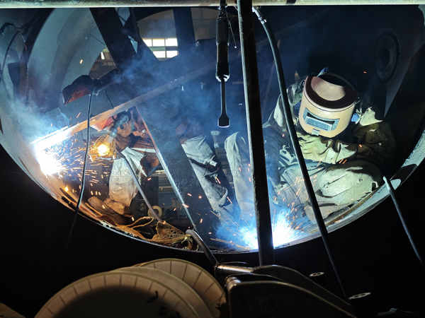 哈電電機焊工正在焊接水電機組伸縮節。王學善攝