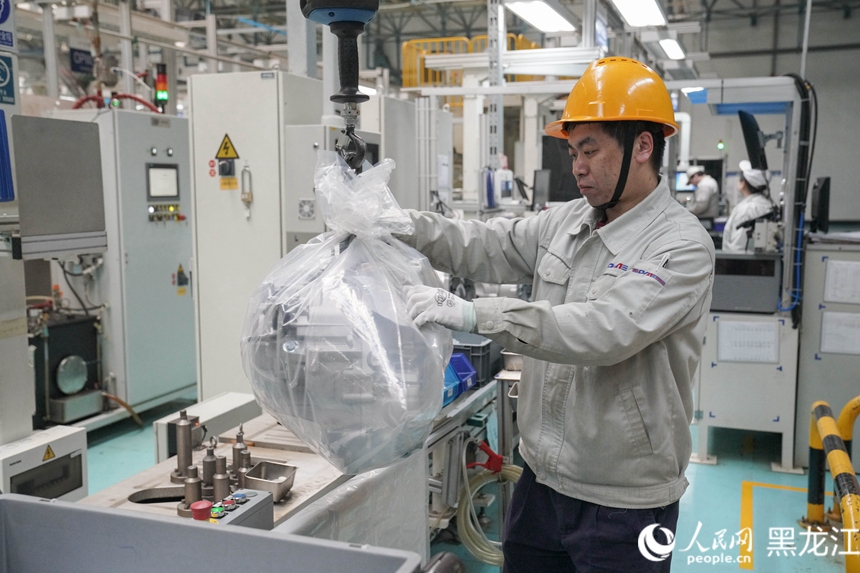 哈爾濱東安汽車動力股份有限公司生產車間，工人在給生產好的產品套上包裝。人民網 徐成龍攝